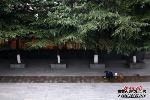 12月7日，侵华日军南京大屠杀遇难同胞纪念馆内的工作人员擦拭幸存者脚印铜板路。中新社jz 泱波 摄